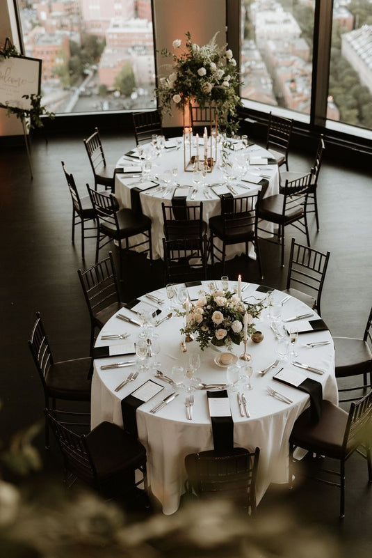 White table linens decorated with black napkins and black chairs